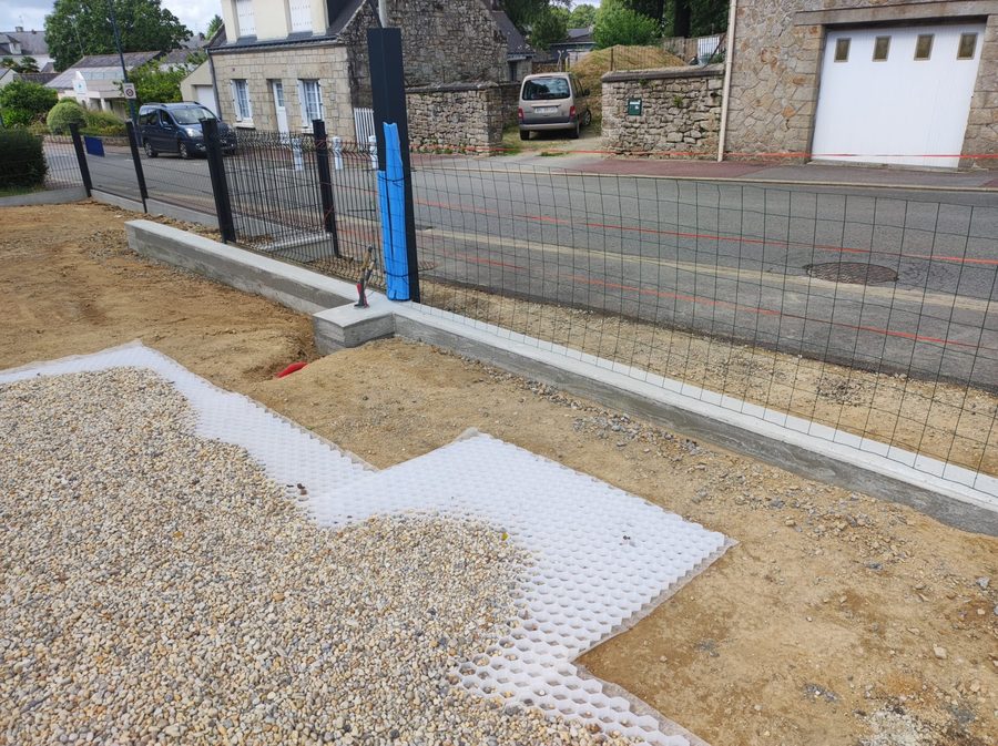 Gravel stabiliser grids, filled and edged, with the low wall and the fencing