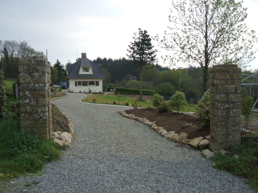 Gravel drive between the stone pillars, up to the house