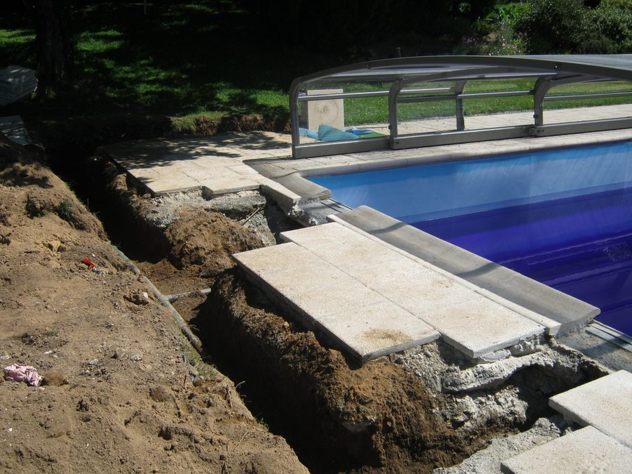 Trench dug alongside a pool to repair the pipework